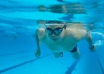 Swimmer wearing swimming goggles underwater in a pool
