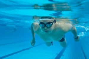 Swimmer wearing swimming goggles underwater in a pool