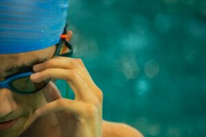 Swimmer wearing a swim cap and goggles at an indoor swimming pool